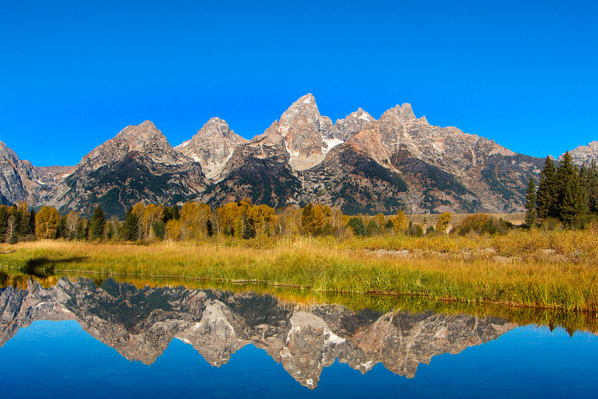 The Tetons reflected in a river in Grand Teton National Park