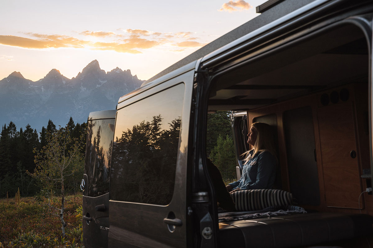 Woman Enjoying View of Teton Mountain Range from Back of Moterra Luxury Campervan Rental
