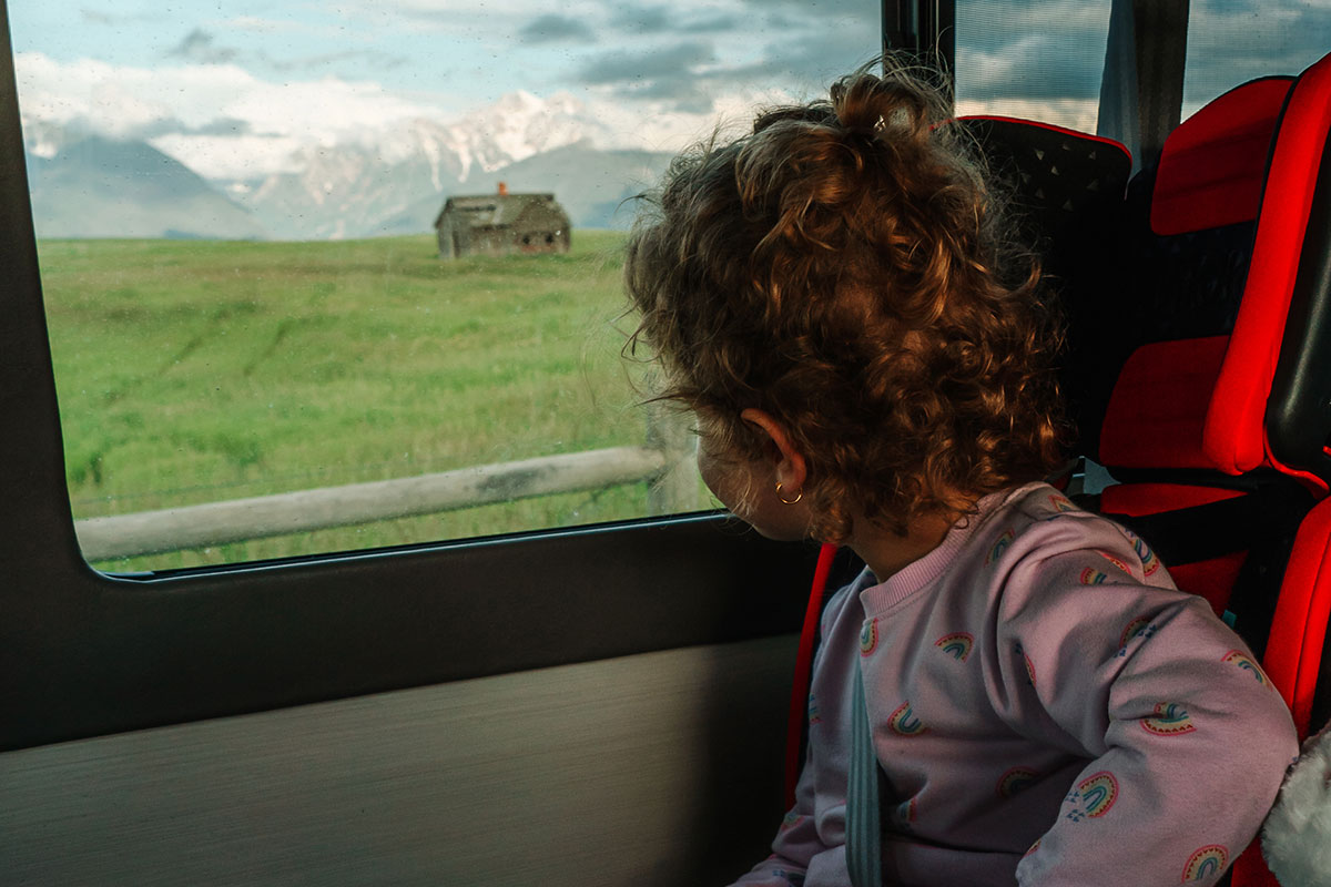 Young Girl Viewing Mountains from a Sprinter Campervan Rental in Grand Teton National Park