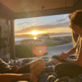 Man and Woman Enjoying Sunset Over Mountains and Lake in Moterra Campervan Rental for Road Trips