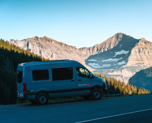 Side View of Moterra Montana Sprinter Campervan Rental in Glacier National Park with Mountains in Background
