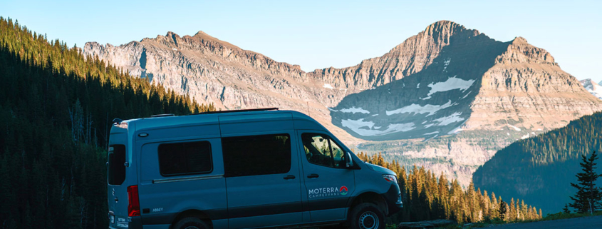 Side View of Moterra Montana Sprinter Campervan Rental in Glacier National Park with Mountains in Background