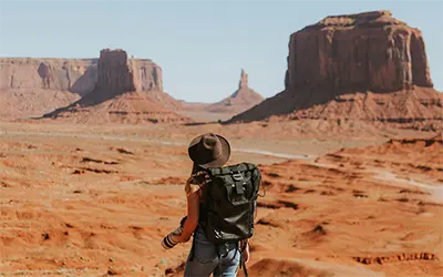 Back of Woman with Hat Hiking in Monument Valley