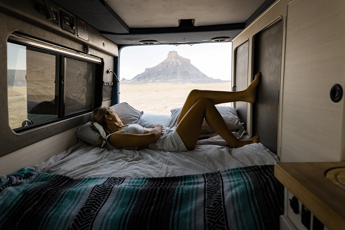 Woman Enjoying Desert View While Lying Down in Utah Campervan Rental