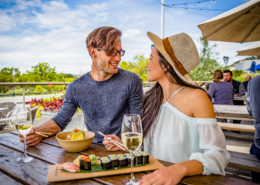 a couple sits with wine and sushi in napa valley